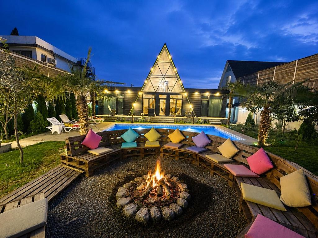 a backyard with a fire pit in front of a house at Qafqaz Mountside Chalet in Gabala