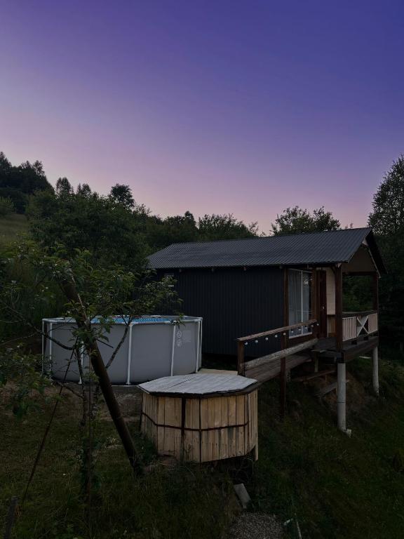 a cabin with a table and a bench in the grass at FoxHome in Khashchovanoye