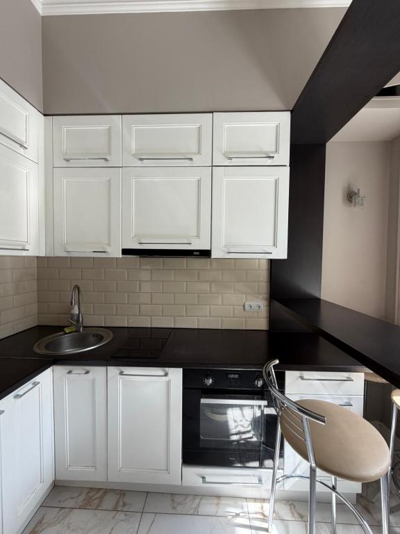 a kitchen with white cabinets and a sink at Historical space in Lviv