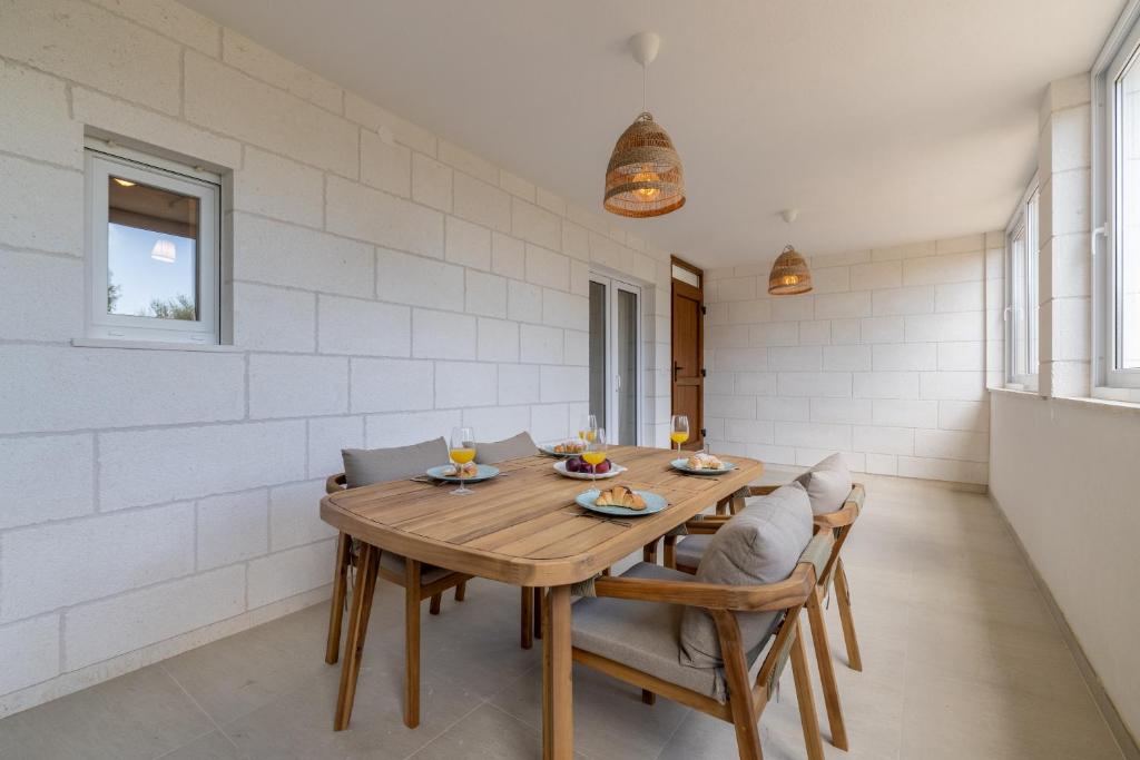 a dining room with a wooden table and chairs at Apartments Lučina in Bol