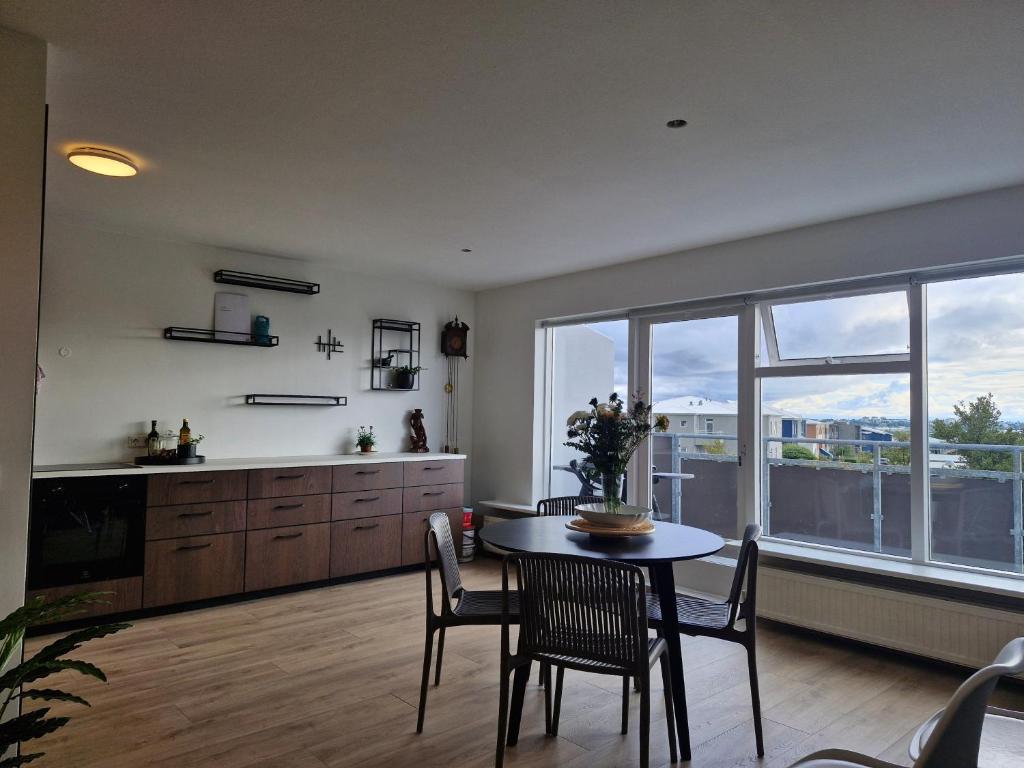 a kitchen and dining room with a table and chairs at Top floor apartment with view in Reykjavík