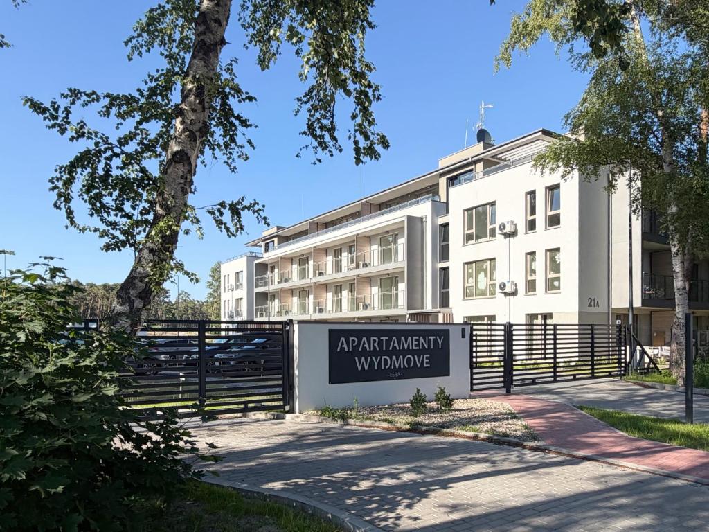 an apartment building with a sign in front of it at Wydmove Łeba Q4 Apartments in Łeba