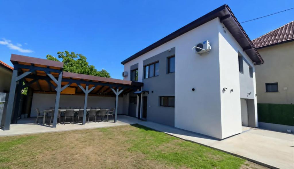 a white house with a patio with a table and chairs at Casa MADE in Turda