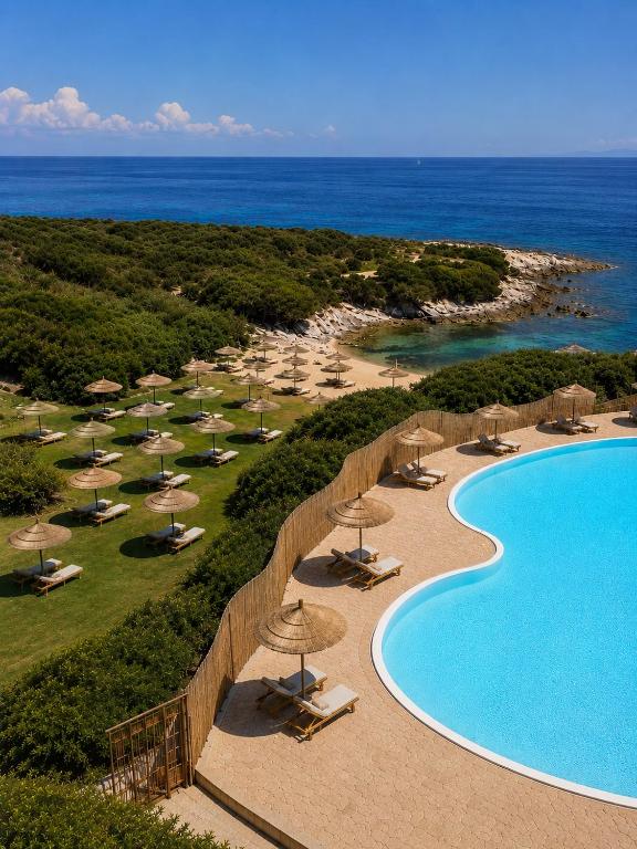an aerial view of a resort with a swimming pool and umbrellas at Cala Lupo Resort in Stintino