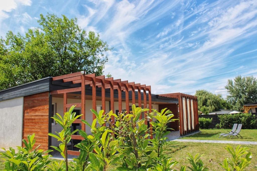 a small house with a wooden fence around it at Fenyves Flow Apartman 1 in Balatonfenyves
