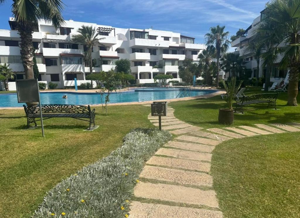 a swimming pool with two benches next to a building at Blue Horizon in Cabo Negro