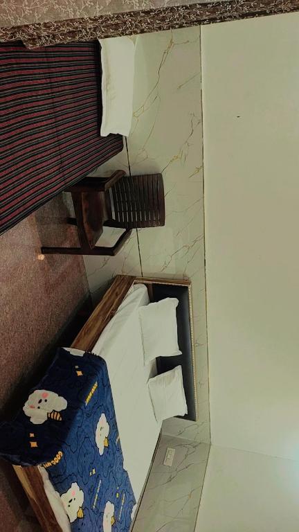 a small room with a bed and pillows at Maa chamunda dham in Mathura