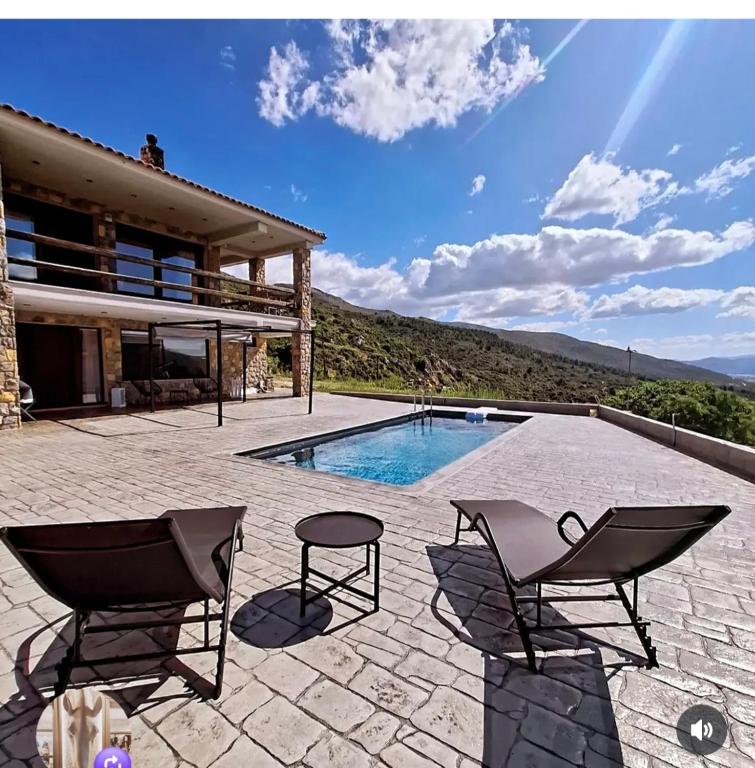 a patio with two chairs and a swimming pool at Το ραχατι in Vília