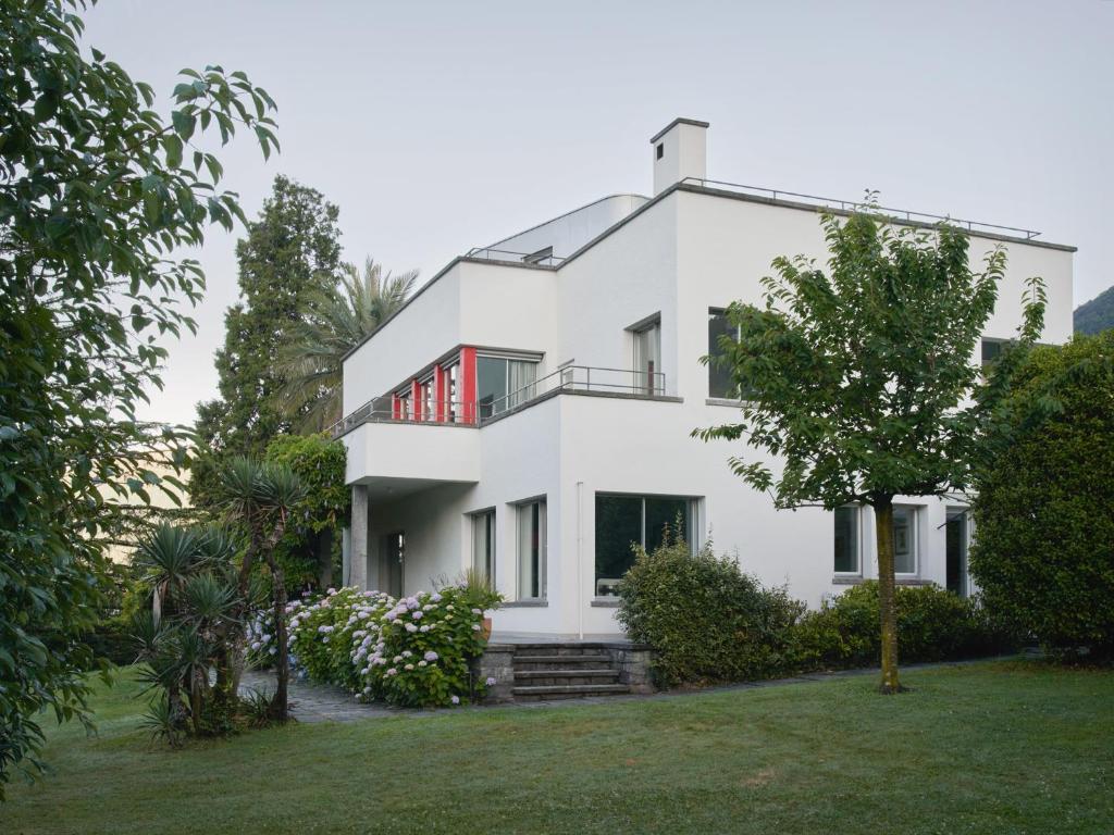 a white house with a tree in front of it at Casa Navegna in Minusio