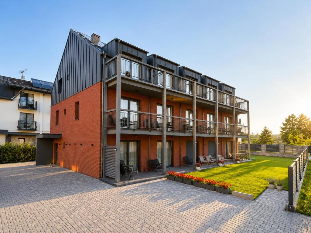 a large red brick building with a courtyard at AMD Apartamenty Ustka *** in Ustka