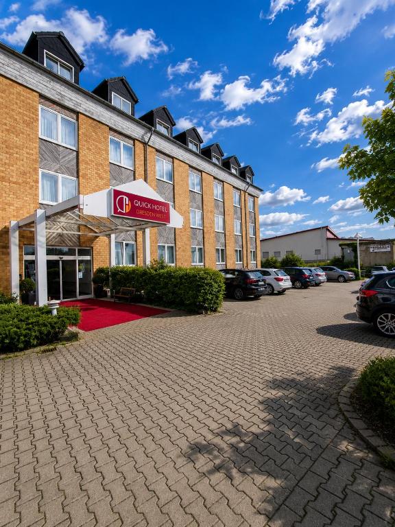 ein Hotel mit einem Parkplatz davor in der Unterkunft Quick Hotel Dresden 24H Self Check-in in Dresden