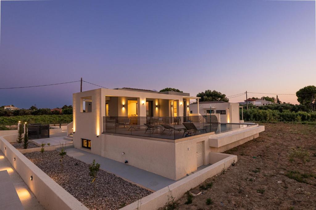 a large white house with a patio in a field at TATOLI Villas in Minia