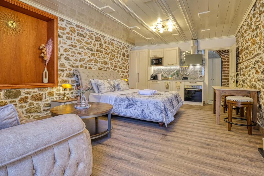 a room with a bed and a couch and a table at Pietra Grand Suite in Nafplio