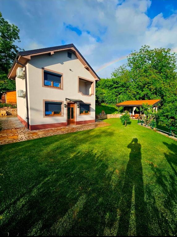 a shadow of a person in the yard of a house at Villa Sara - Apartments & Garden, Kratovo in Kratovo