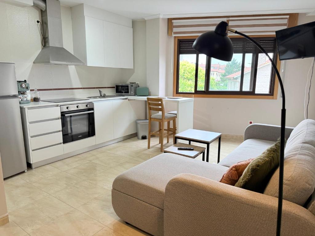 a living room with a couch and a kitchen at Estudio en Villalonga in Pontevedra