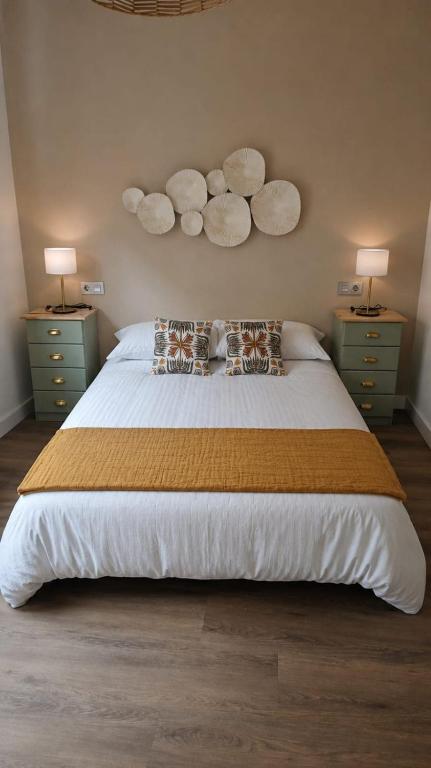 a bedroom with a large bed with pillows and two night stands at Casa A Beira do Mar in O Grove