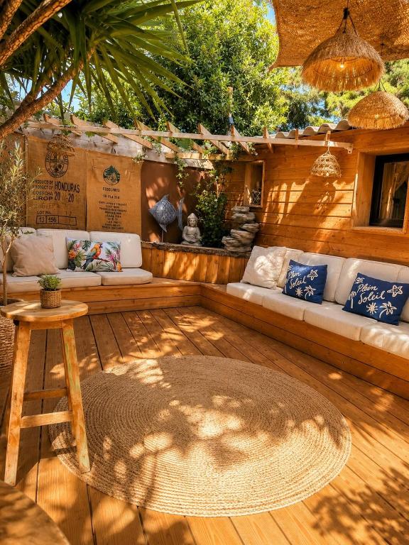 a living room with a couch and a table at Le Tiki Lodge in Fréjus