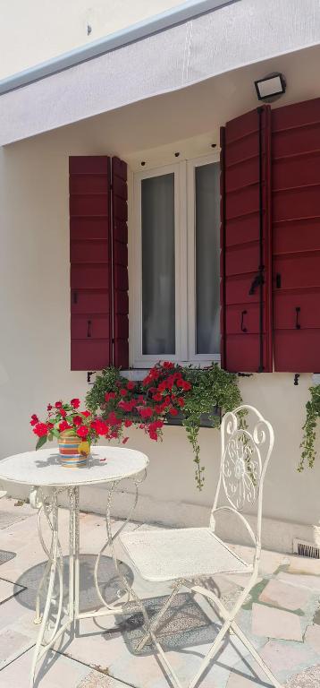 a white chair and a table in front of a building at B&B di Cristina in Conegliano