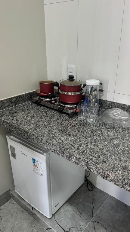 a kitchen counter with some pots and pans on it at Mini flat 08 em Jataí Go in Jataí