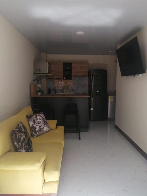 a living room with a yellow couch and a kitchen at Comodo aparta estudio en Jerico Antioquia in Jericó