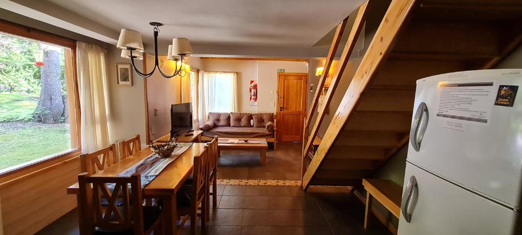 a kitchen and living room with a table and a refrigerator at Matices Patagonicos in San Carlos de Bariloche