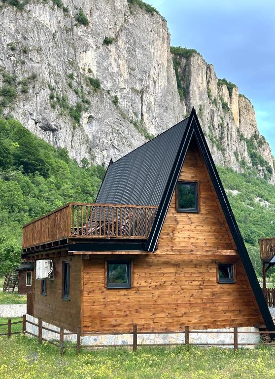 a log cabin with a deck on the side of a mountain at Komarnica Forest Owl 2 in Šavnik