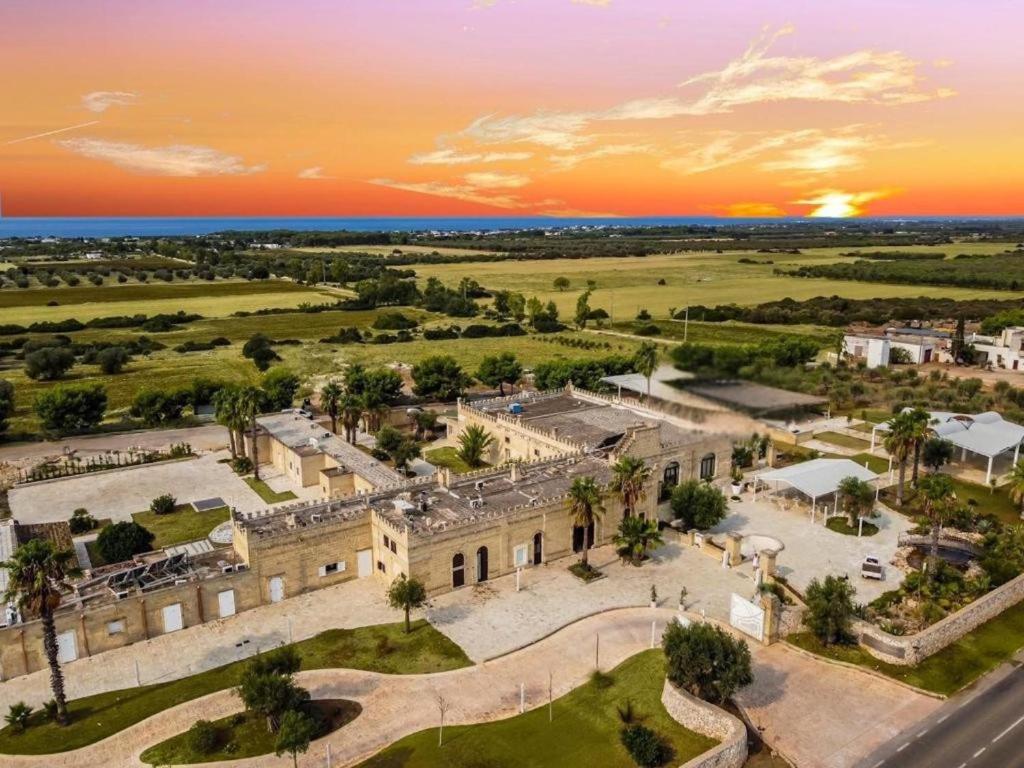 an aerial view of a building with a sunset in the background at Masseria Tenuta Quintino in Torre Lapillo