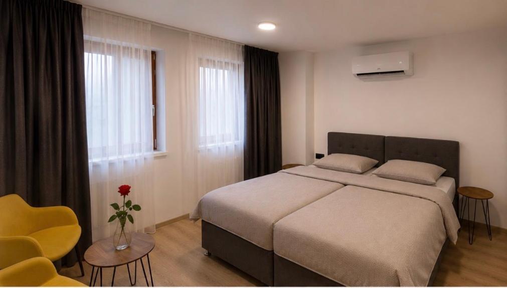a bedroom with a large bed and a yellow chair at Rooms Aura Kanal in Kanal