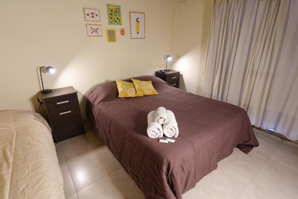 a bedroom with a bed with two towels on it at El Retorno Hostel in Puerto Madryn