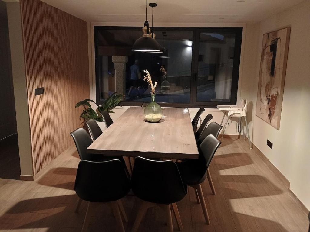 a dining room table with chairs and a vase on it at A de Amancio in Sayáns
