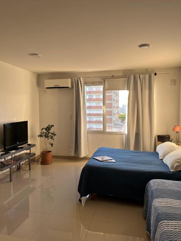 a bedroom with a bed and a flat screen tv at Blandengues 55 in Bahía Blanca