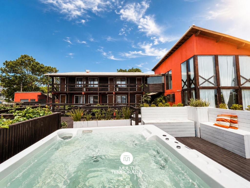 an outdoor hot tub in front of a house at Pousada Solar dos Lírios - Praia do Rosa in Praia do Rosa