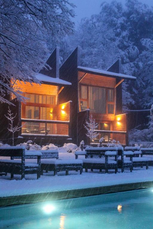 a house with a swimming pool in the snow at Ni-Newen Hotel & Lodge in Pucón
