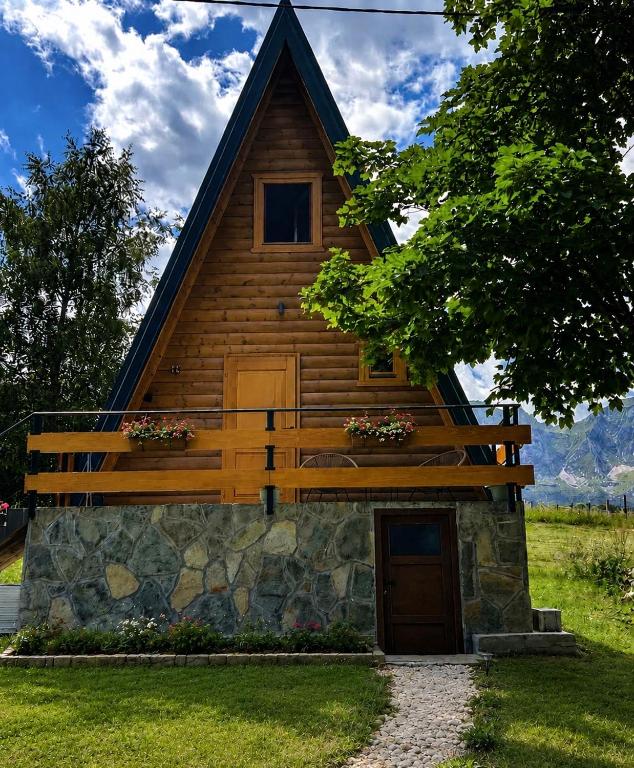 a cabin with a gambrel roof on top of a stone wall at House Durmitorski konak in Virak