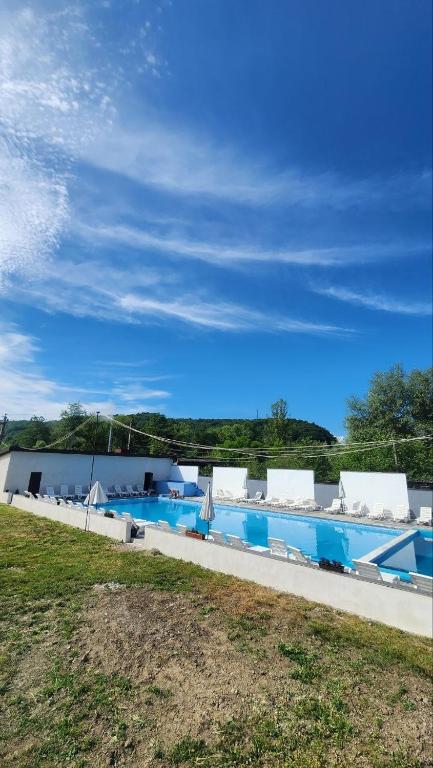 a large swimming pool with chairs and a blue sky at Happy Time in Sredneye Vodyanoye