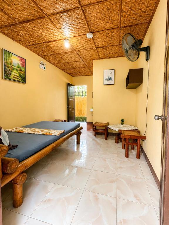 a large room with a bed and a table at Argana Cottages in Dauin