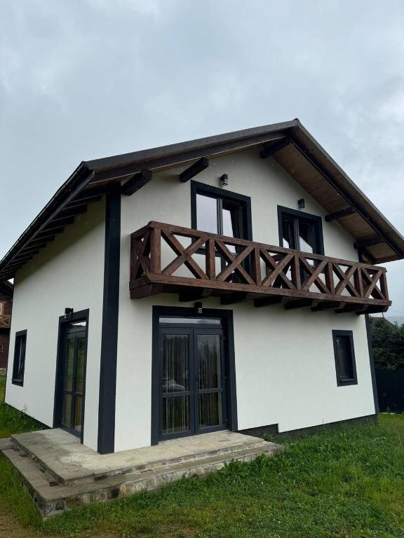 a white and black house with a wooden roof at Grey House in Vorokhta
