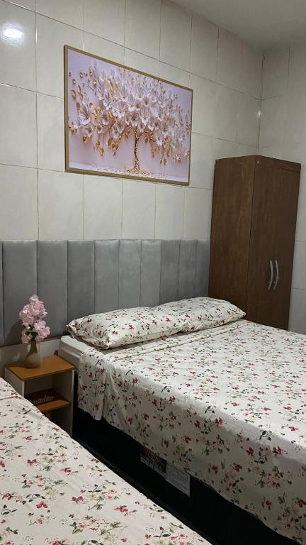 a room with two beds and a picture on the wall at Central APE Diamantina in Diamantina