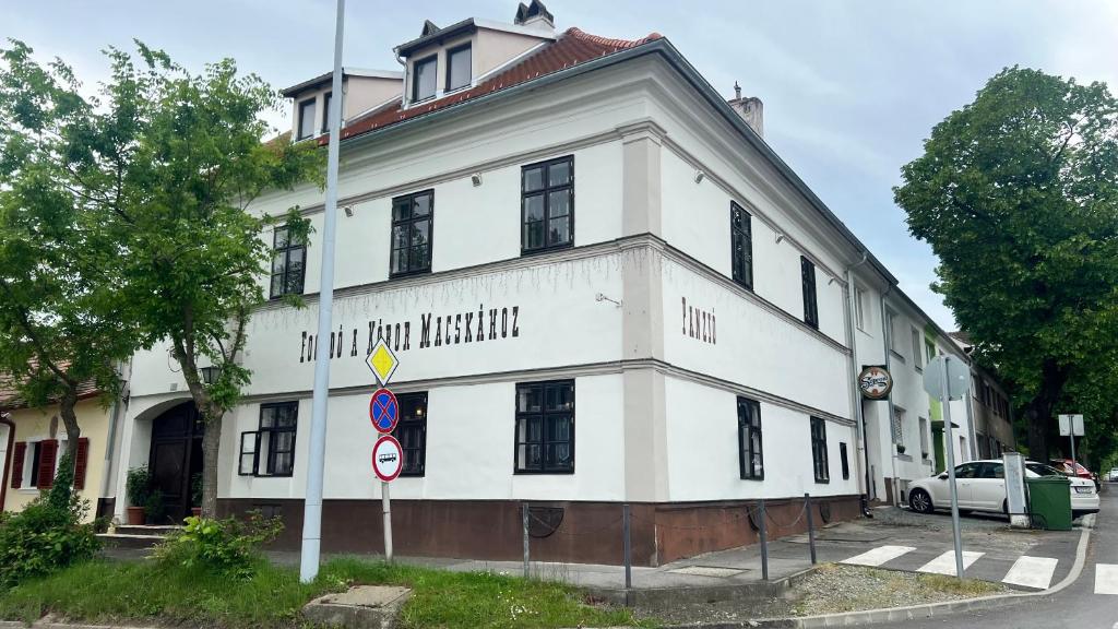 a white building with a sign in front of it at Fogadó a Kóbor Macskához in Kőszeg