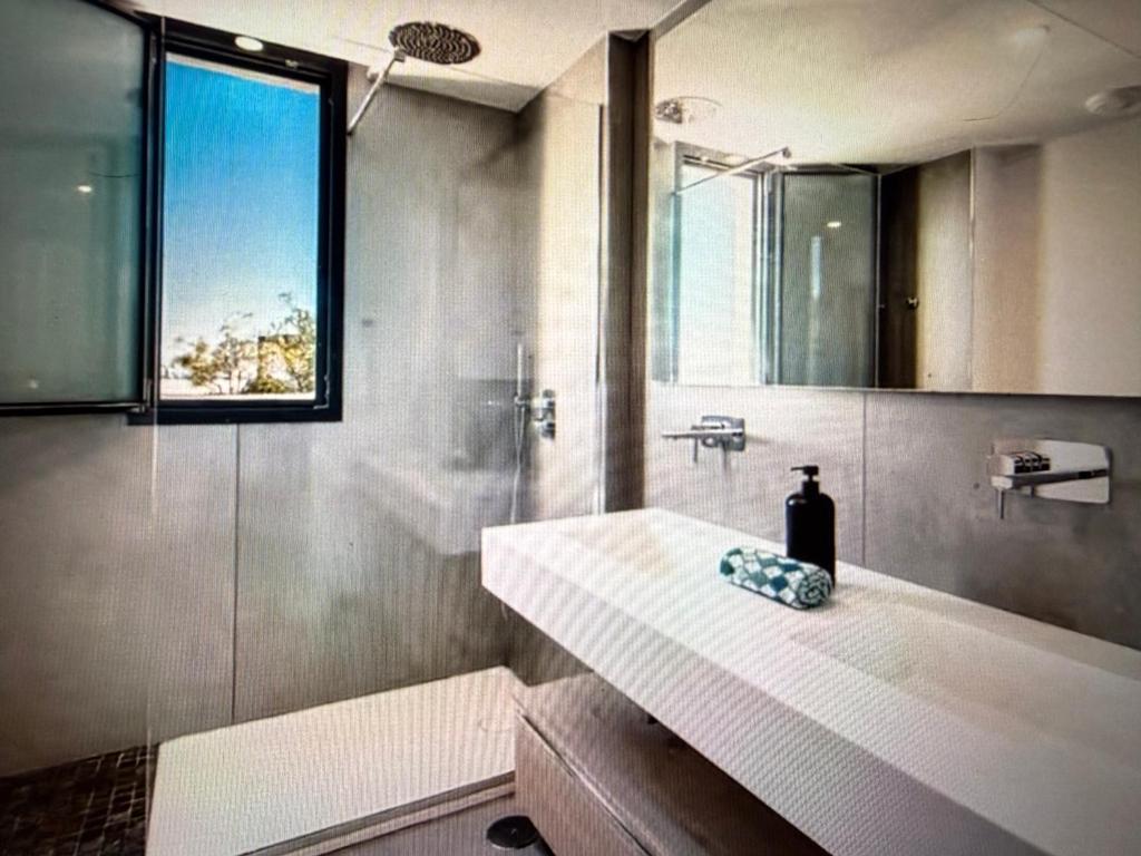 a bathroom with a sink and a shower with a mirror at Luxury Villa Private Pool in Mahajanga