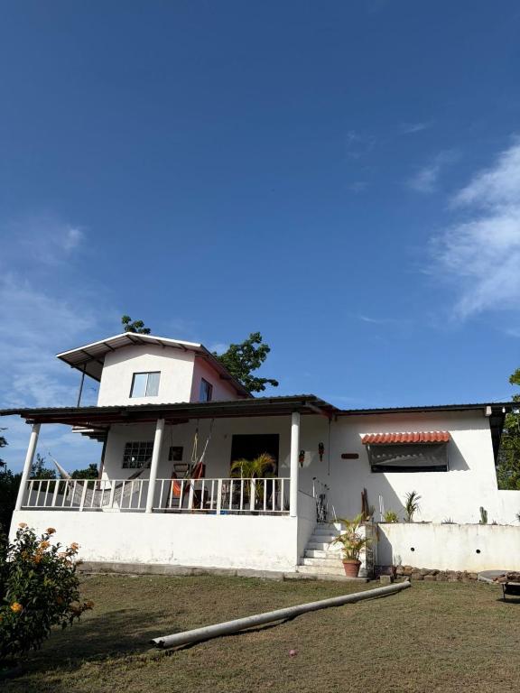 a white house with a balcony on the side at Senderos de Ana in San Carlos