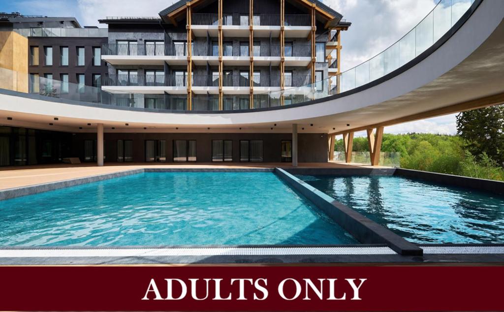a large swimming pool in front of a building at Harmony Valley Resort in Szklarska Poręba