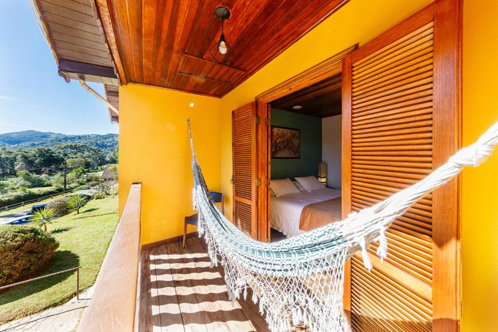 a hammock on the balcony of a house at Pousada Sonho Verde in Monte Verde