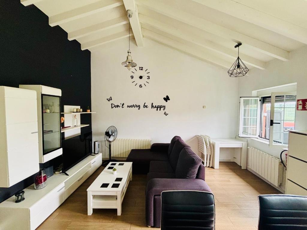 a living room with a couch and a clock on the wall at La Casita cerca de la playa in Santander