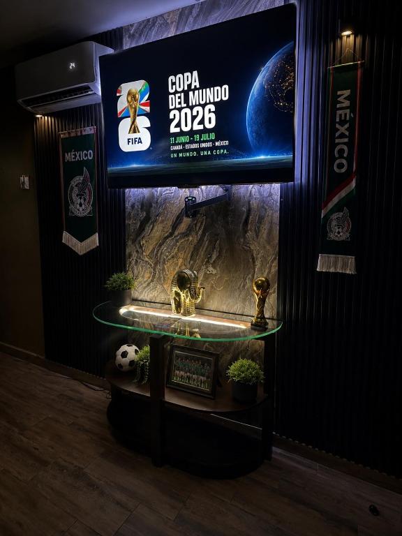 a television with a sign on a wall with plants at Departamento Mateo'S 505 in Ciudad Acuña
