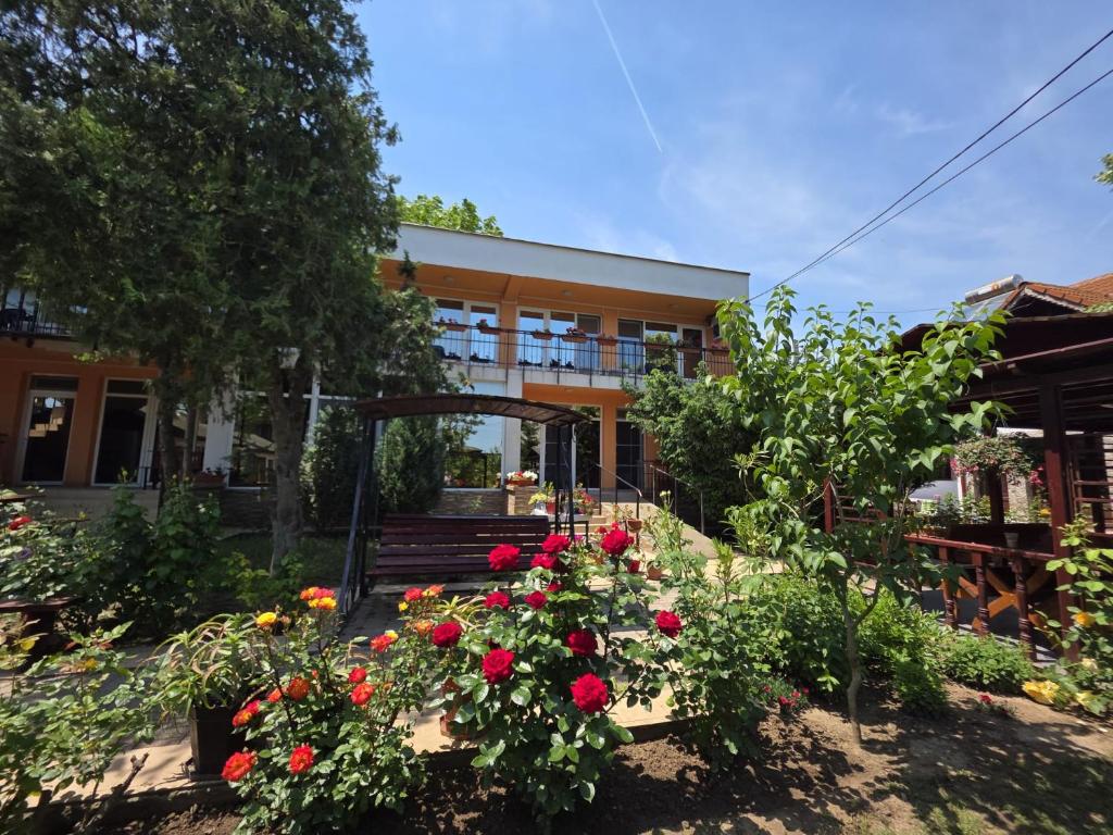 a building with a bunch of flowers in a yard at Vila Madi in Vama Veche