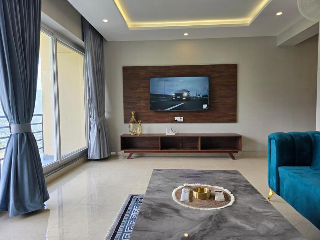 a living room with a tv on a wall at Murree Spring Apartment in Murree