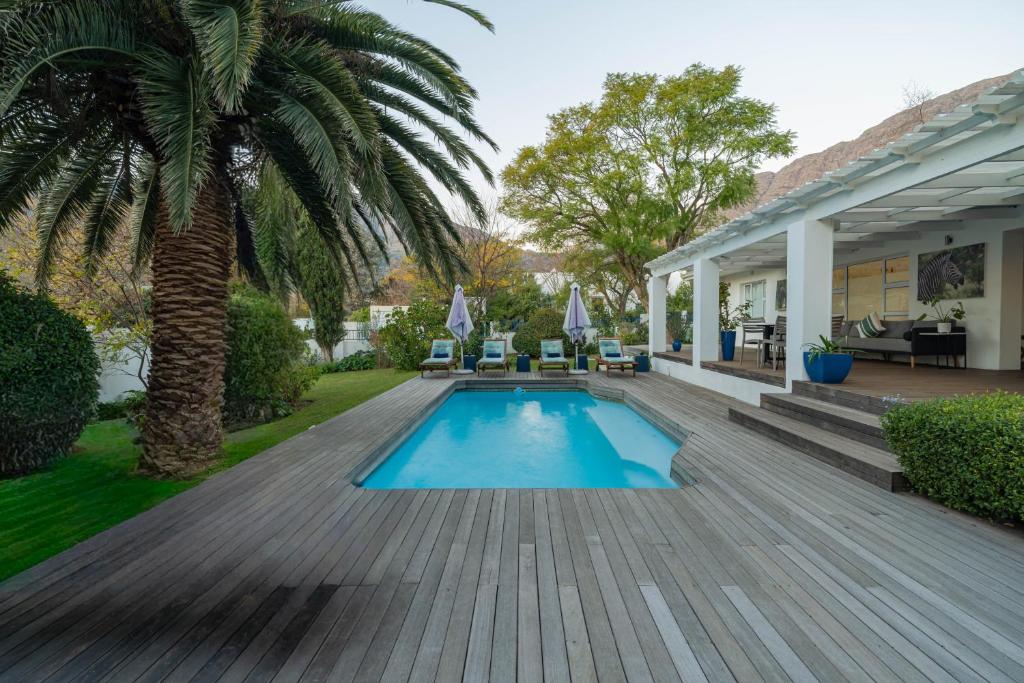 a backyard with a swimming pool and a wooden deck at theLAB BLUE in Franschhoek
