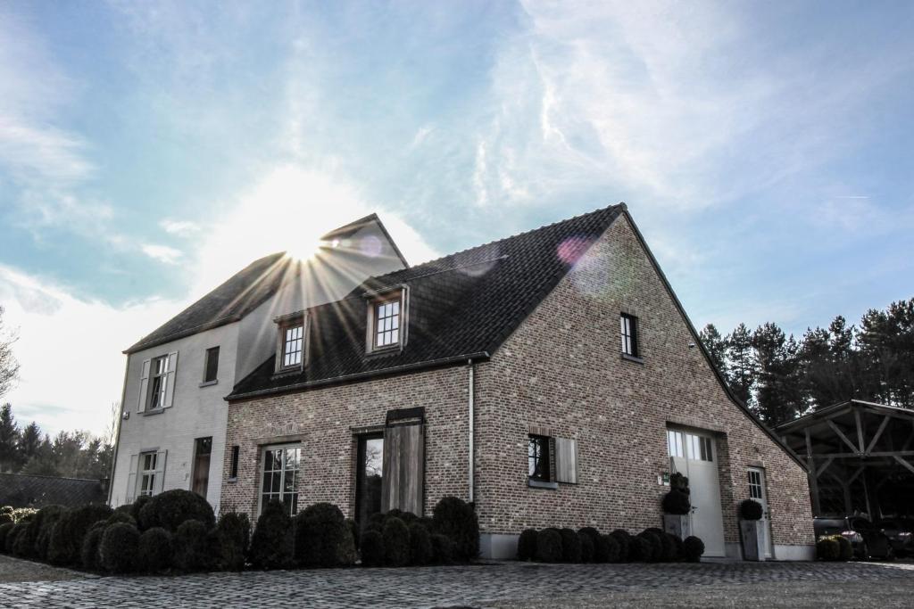 una casa di mattoni con il sole che splende sopra di B&B de ZIL a Herselt