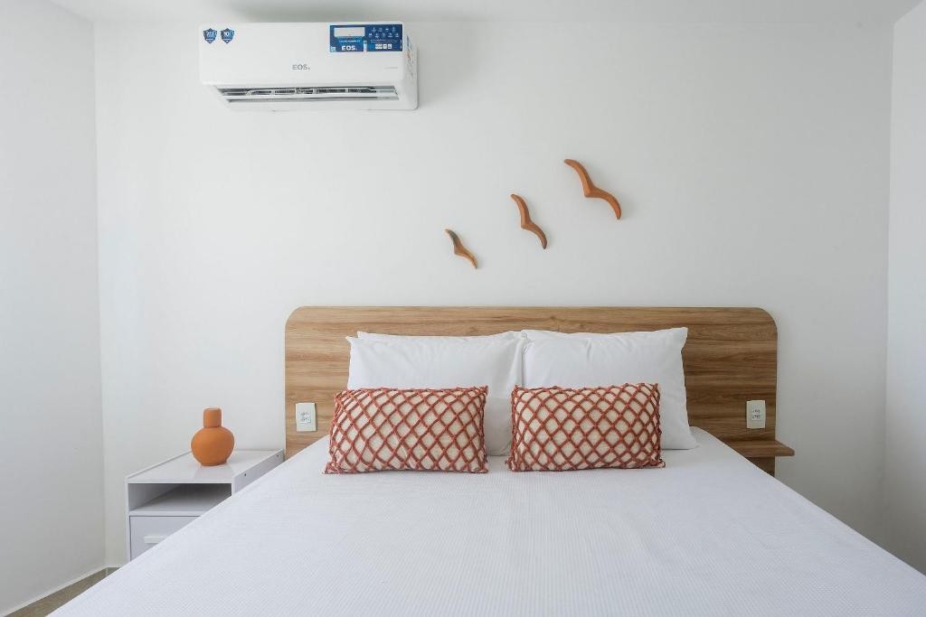 a bedroom with a white bed with two pillows at Apartamentos mobiliados em Caruaru in Caruaru